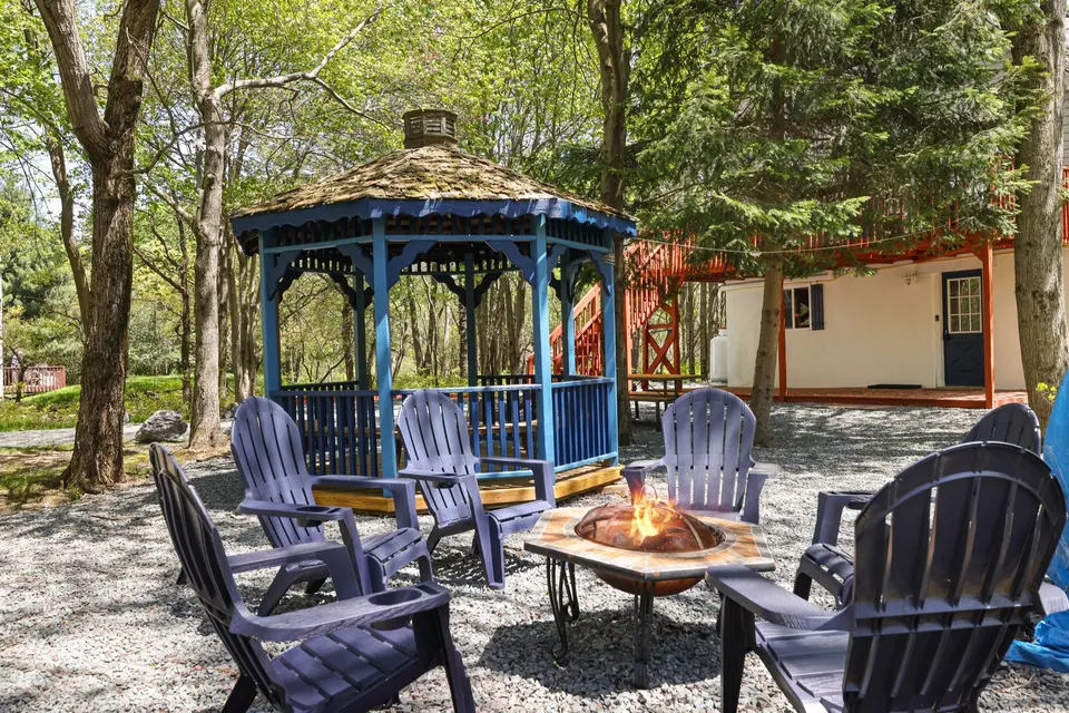 The gazebo, fire pit and Adirondack chairs at 284 Cedar, a home Ideal manages in Long Pond