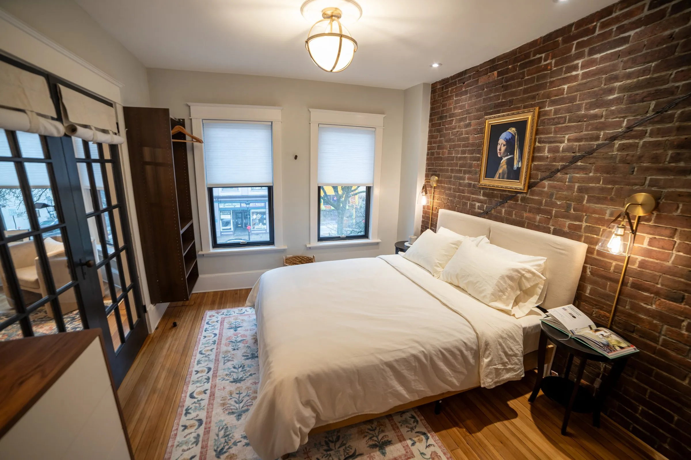A bedroom with an exposed brick wall in the third-floor unit at the Stroudsburg property
