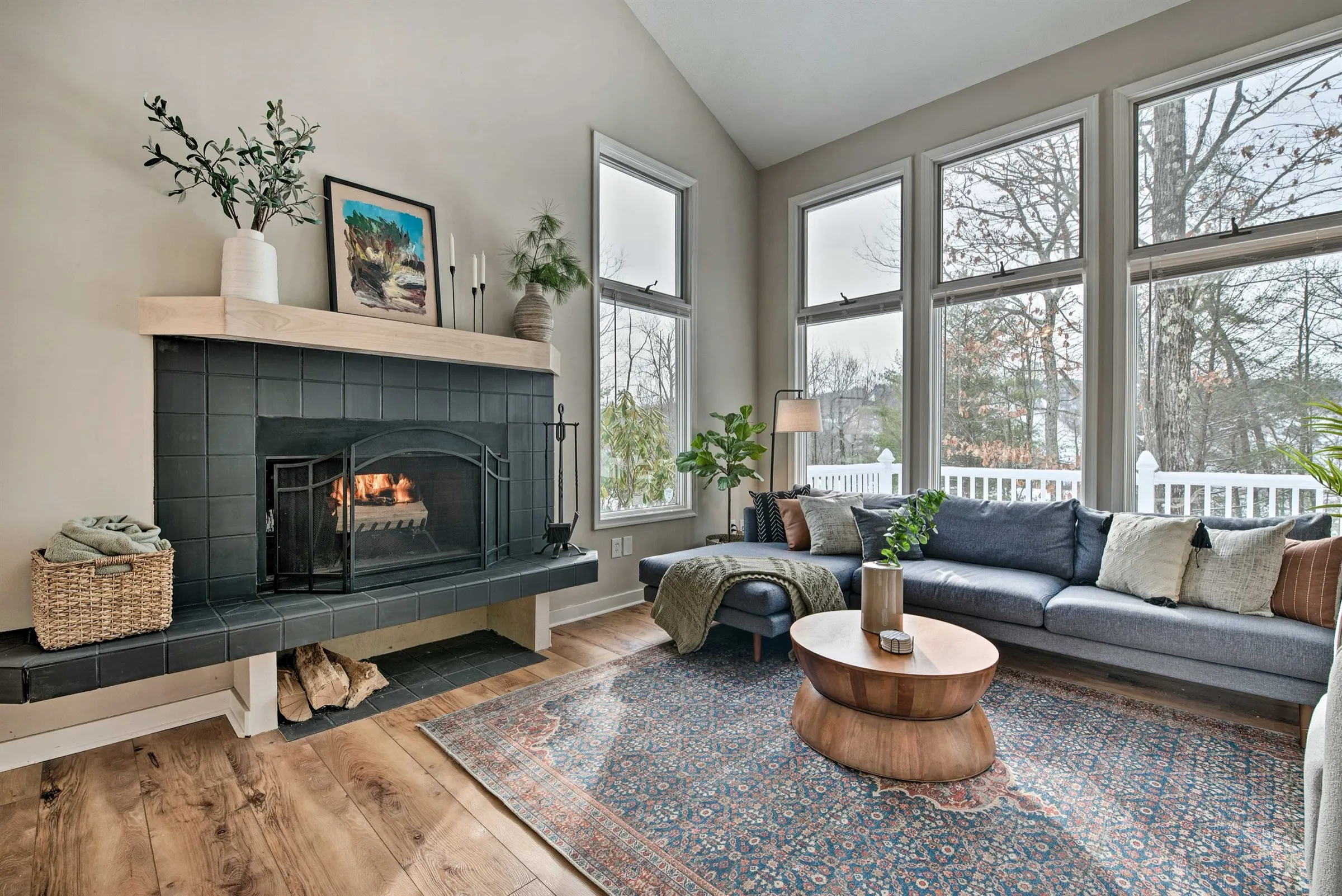 The living room of a Poconos home Ideal manages, with a fireplace and tall windows